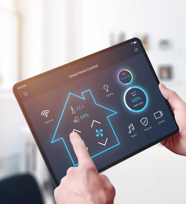 Man using a smart home app on a tablet to control electronics throughout his house.