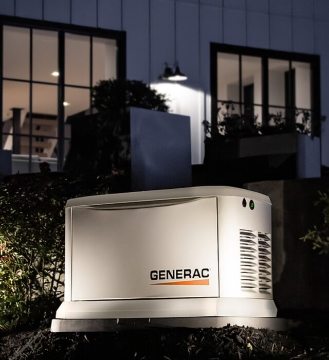 Generac generator installation with outdoor lighting illuminating the standby generator.