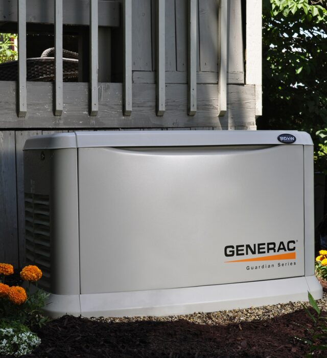 Generac whole-home generator installation next to wooden deck.