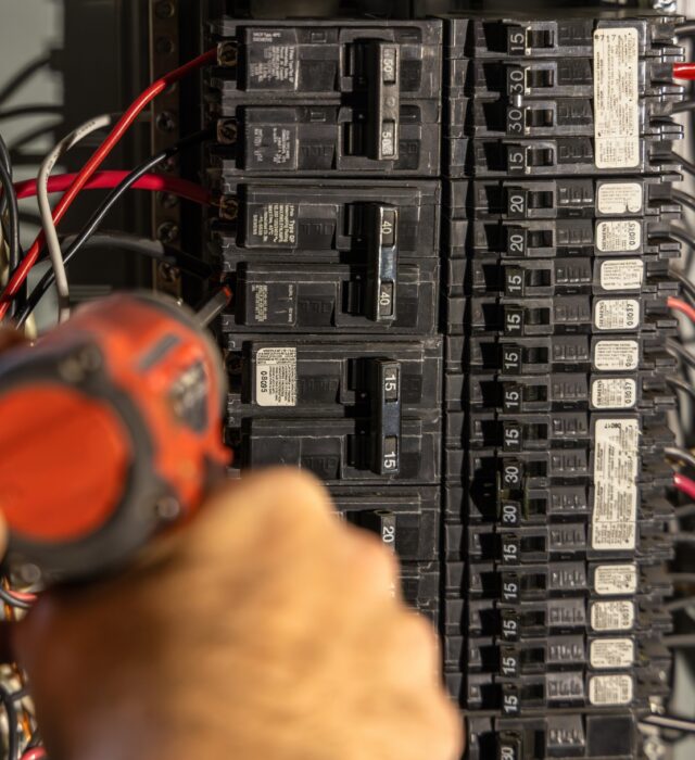A residential electrician doing electrical repairs on a faulty circuit breaker.
