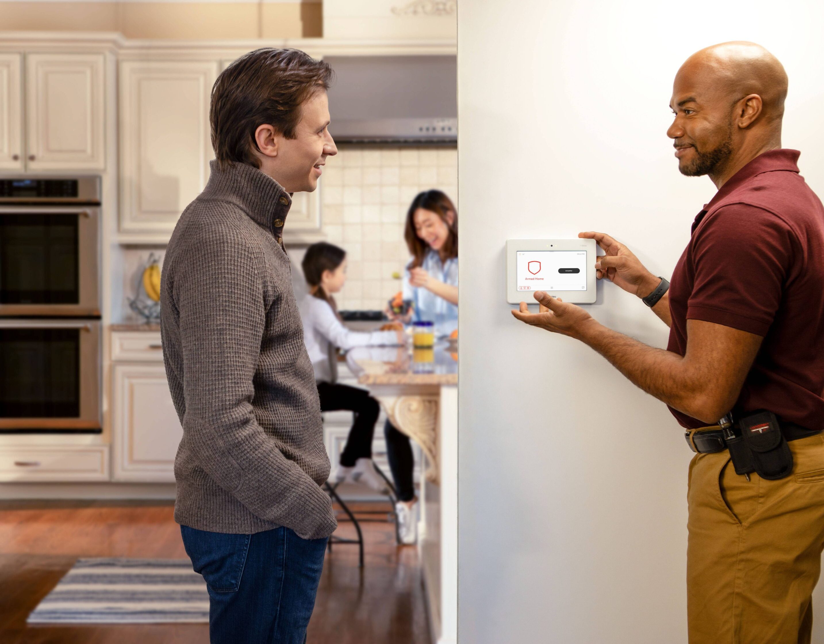 Dad speaking with a home security service technician in Texas who is explaining a newly installed home security system.