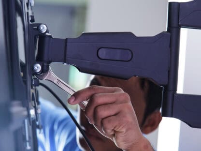 Technician Installing a TV Mount to Hang a Large Flatscreen TV to the Wall