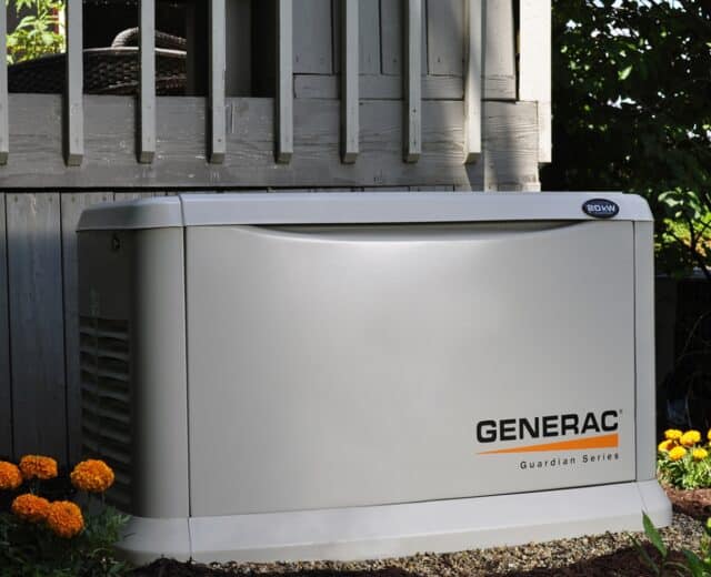 Generac generator installed next to deck.