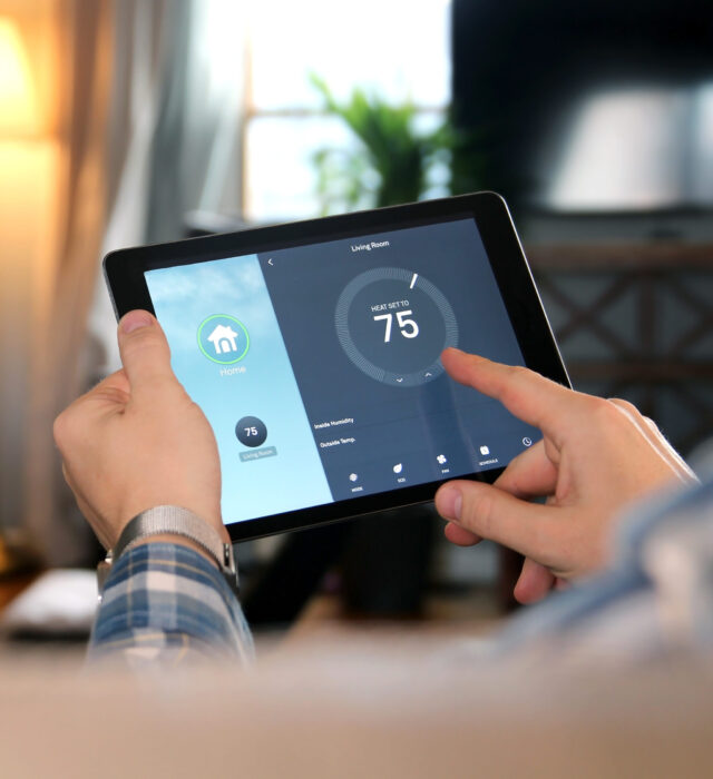 A homeowner controlling the home's temperature through an app on a touchscreen device.