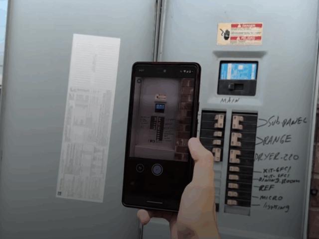 Homeowner taking a picture of their electric panel ahead of an online generator consultation.